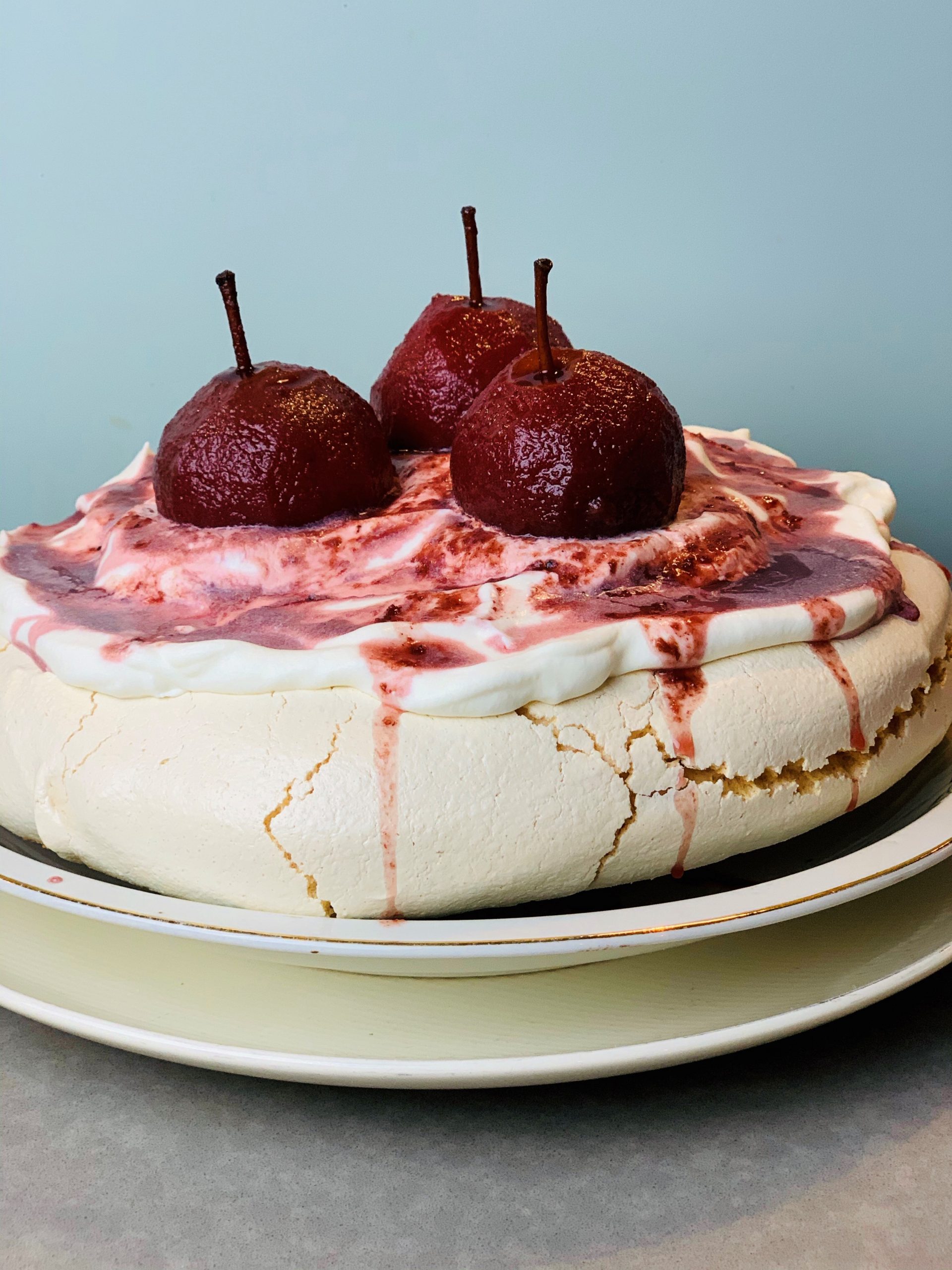 Pavlova met stoofpeertjes en rode bessensap. Een heerlijk feestelijk en winters dessert wat prachtig zal staan op de kerst tafel.